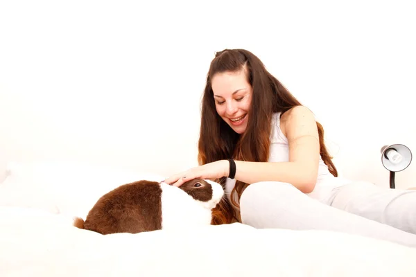 Caressing a rabbit in bed — Stock Photo, Image